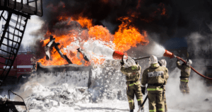 Firefighters extinguishing fire using foam