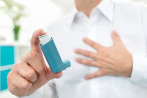 a man holds an asthma inhaler in his hand