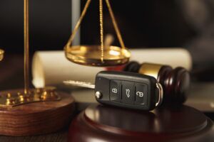 car accident law concept- car key beside a hammer and gavel