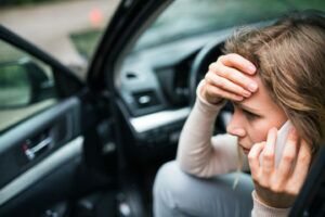 woman calling on her phone after a car accident