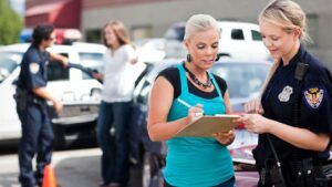 A woman is asking a police officer to provide her with a report of a car accident