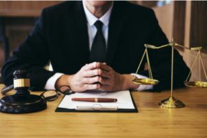 fayetteville social security disability attorney with his hands over a document, with pen and gavel and hammer on the side