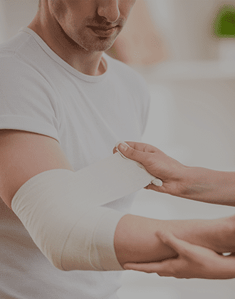 doctor wrapping a man's arm with gauze