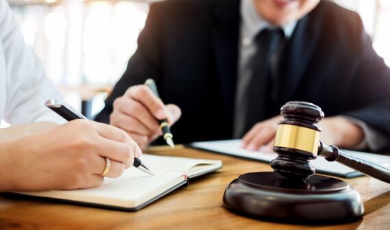 truck accident attorney holding a pen with papers and gavel and hammer in front of him